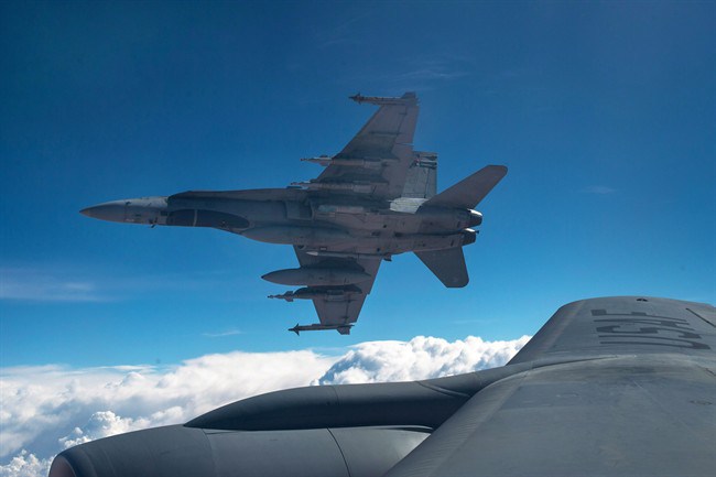 A Royal Canadian Air Force CF-18 Hornet breaks away after refueling with a KC-135 Stratotanker assigned to the 340th Expeditionary Air Refueling Squadron, Thursday, Oct. 30, 2014 over Iraq.